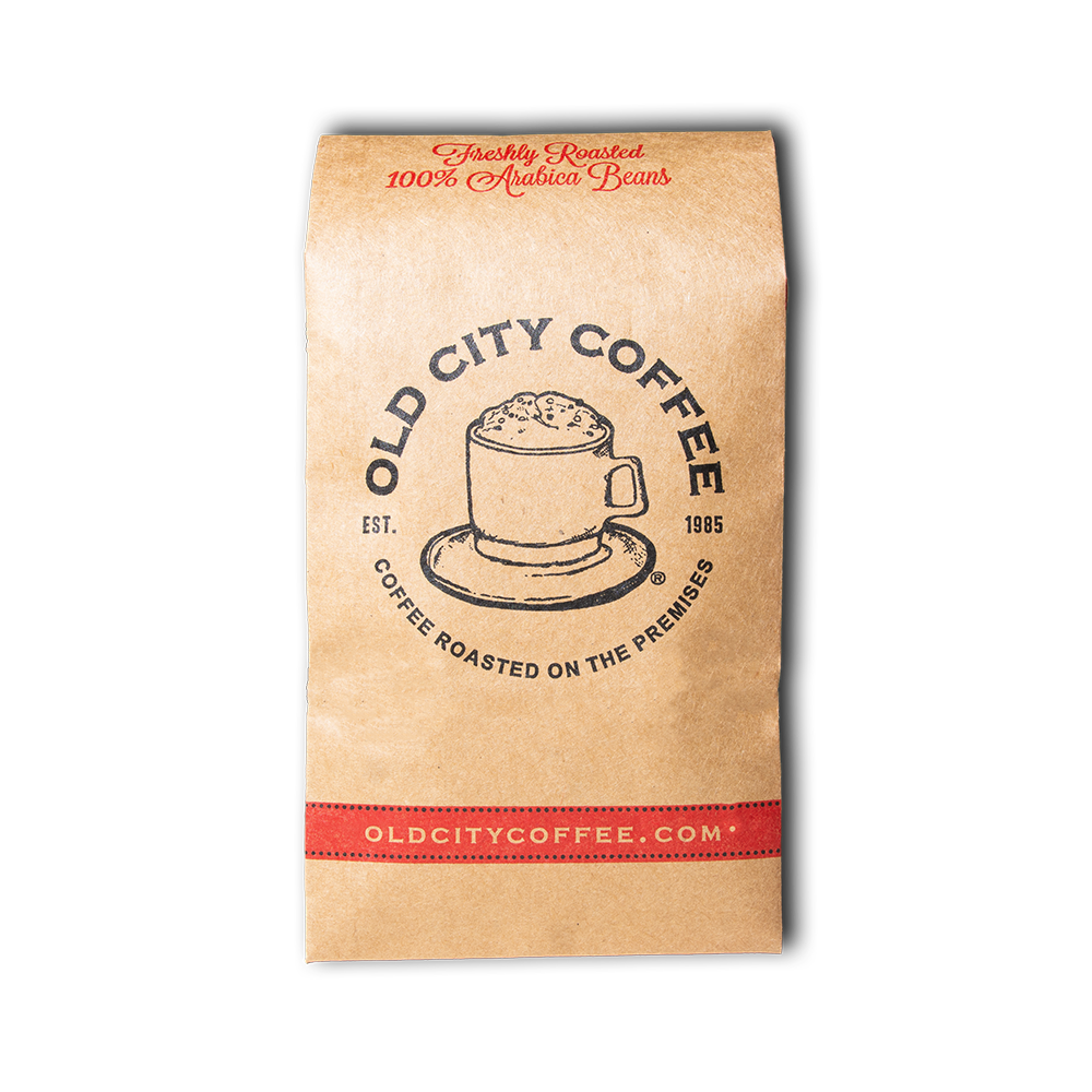 A natural Kraft paper bag of Old City Coffee, featuring a graphic of the vintage Old City Coffee logo and the brand's website with red and black accents