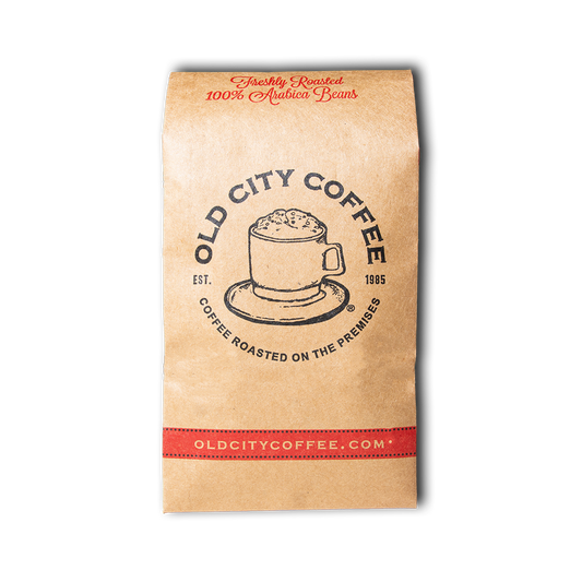 A natural Kraft paper bag of Old City Coffee, featuring a graphic of the vintage Old City Coffee logo and the brand's website with red and black accents